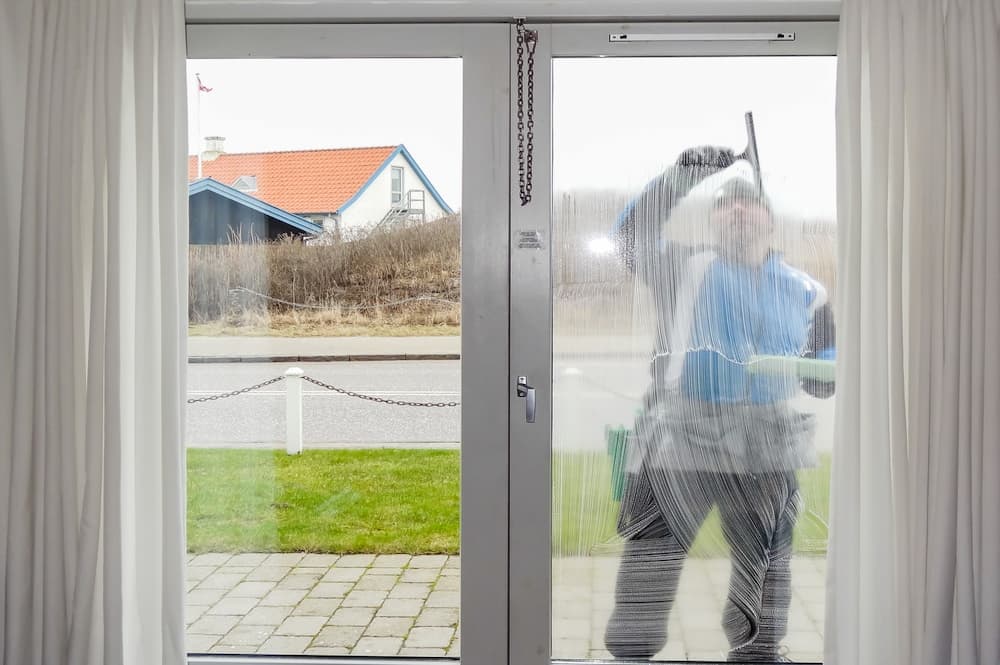 Vinduespudser arbejder på rene ruder i en bolig i Stenløse – professionel vinduespolering fra CL Polering
