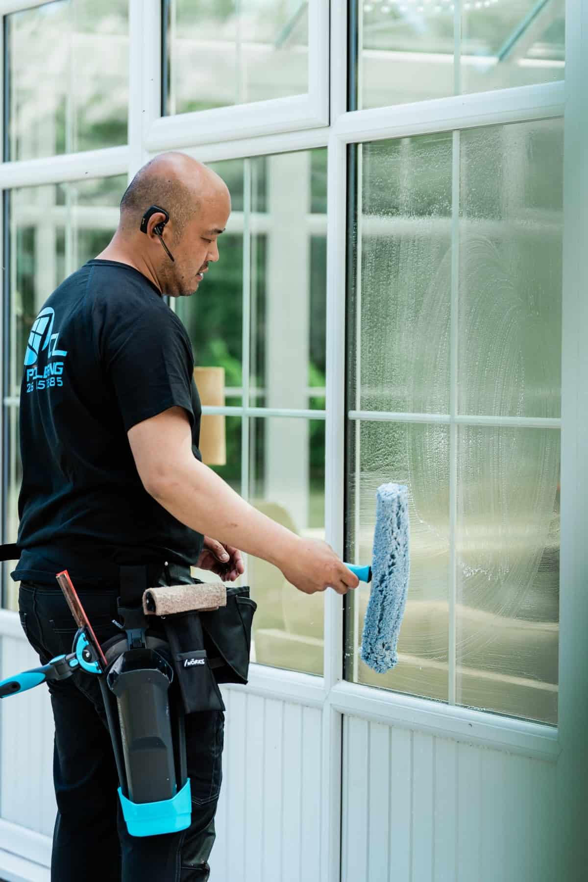 Vinduespudser vasker en rude med en indvasker